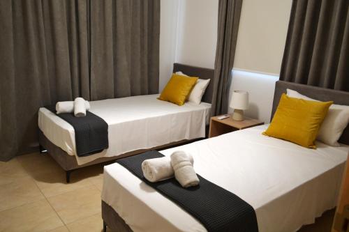 帕拉利米尼Sweet Retreat的一间卧室配有两张带黄白色枕头的床