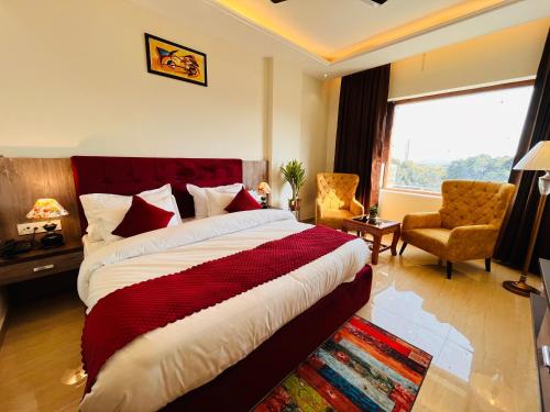 哈里瓦Ganges blossam - A Four Star Luxury Hotel & Resort的卧室配有床、椅子和窗户。