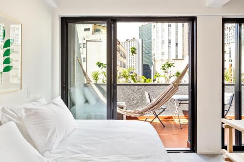 圣保罗Tabas - Ed. Magdalena Laura - Vila Buarque的一间卧室设有一张床,阳台上设有吊床