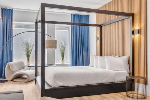 魁北克市Initial / Libre / Centre-ville de Quebec的一间卧室配有一张带桌子和椅子的天蓬床