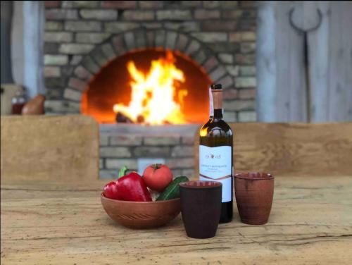 KrekhayevZubyria Lodge的壁炉前的一瓶葡萄酒和一碗苹果