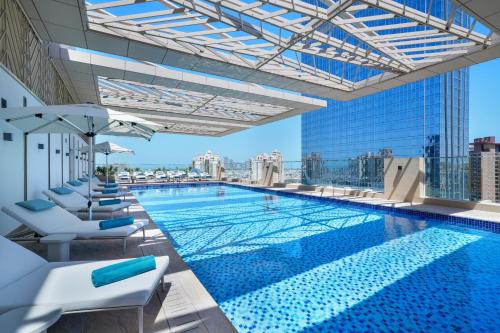 迪拜仕骅廷迪拜棕榈岛梅森酒店的一座大楼顶部的游泳池