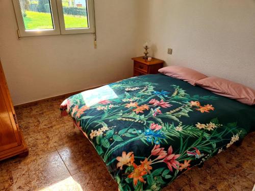 NavecesPreciosa Casa de Campo + Playa + Jardín + Mascotas的一间卧室配有一张带彩色毯子的床
