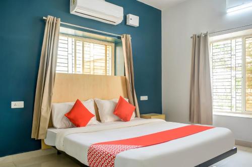 KhandagiriWelcome Inn Near DN Regalia的一间卧室配有一张带红色枕头的大床