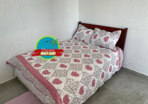 伊瓜苏Chacara Beach Lazer的一张带粉色和白色棉被及枕头的床