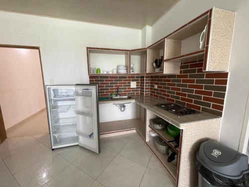 托卢Edificio Itzé SOLARIS apto 2 habitaciones的带冰箱和砖墙的小厨房