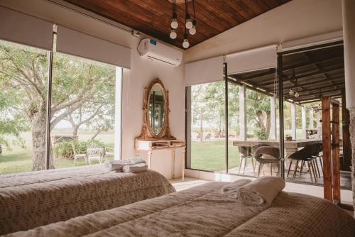 卡梅隆El Rincón. Farm and Lodge的配有2张床的带大窗户和桌子的客房