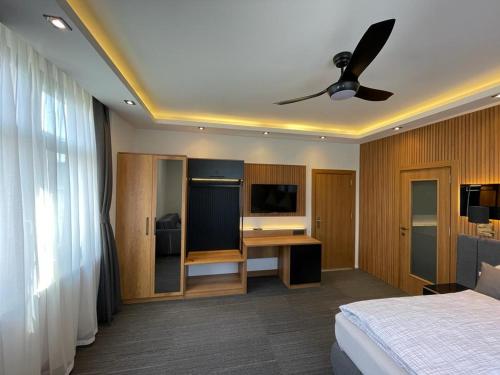 乌尔丁根-米赫尔霍芬乌尔盯格霍夫宾馆的一间卧室配有一张床和一张带吊扇的书桌