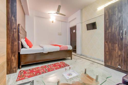 巴特那OYO Flagship 78696 Hotel Kamini的一间卧室配有一张床和一张玻璃桌