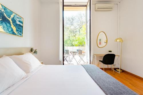 巴塞罗那Casa Lolita的卧室配有一张白色大床和一张书桌