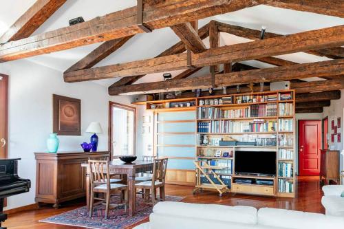 威尼斯Le Mansarde Deluxe的客厅配有桌子和书架