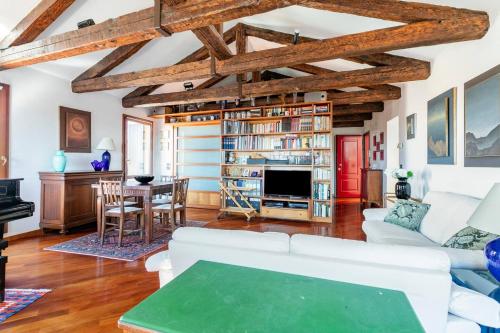 威尼斯Le Mansarde Deluxe的客厅配有白色家具和木制天花板。
