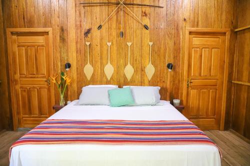 圣加布里埃尔－达卡绍埃拉POUSADA BAWARY的一间卧室配有一张带木墙和木橱柜的床。