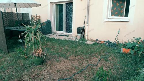 阿纳齐Maison au calme a Arnage的种植植物和雨伞的院子