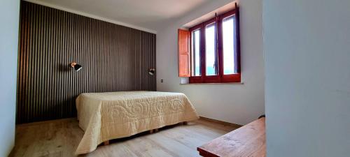 莫拉诺卡拉布罗Pollino House的一间卧室设有一张床和一个窗口