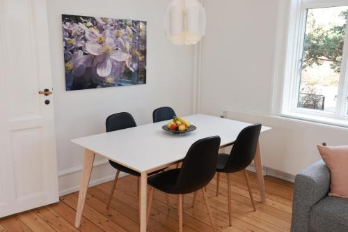夏洛滕隆Scandi-Hygge Seaside House - only 10mins to Copenhagen的一间配备有白色桌椅的用餐室