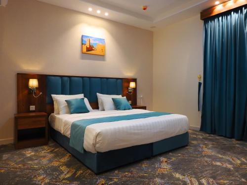 艾卜哈انباك للشقق المخدومه的一间卧室配有一张带蓝色窗帘的大床