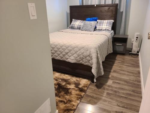 温尼伯Winnipeg Peace Home的一间卧室配有一张床,铺有木地板