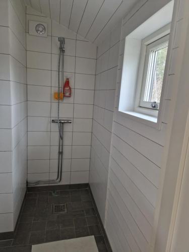 维斯比Fräscht, spatiöst hus的白色瓷砖浴室设有淋浴和窗户