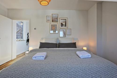 杜塞尔多夫Stylish 3BR apartment -10min to Hbf, full kitchen, homeoffice, Netflix, Wifi的一间卧室配有一张大床和两条毛巾