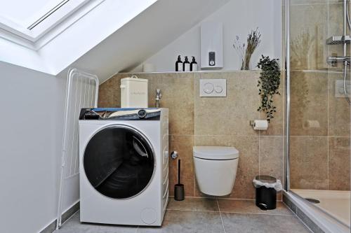 杜塞尔多夫Stylish 3BR apartment -10min to Hbf, full kitchen, homeoffice, Netflix, Wifi的洗衣机以及带卫生间的浴室。