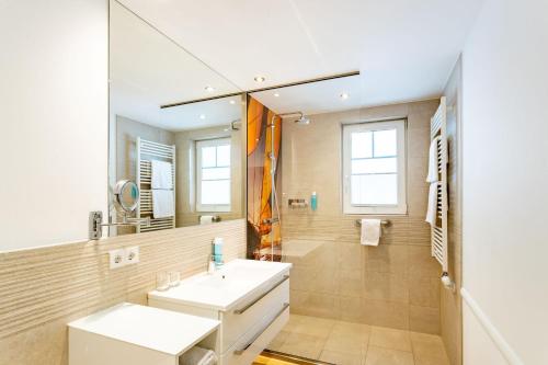 巴特萨罗皮斯库夫Victoria Suites的一间带水槽和镜子的浴室