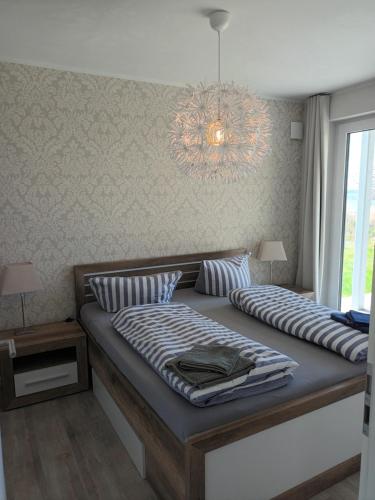 阿尔特费尔Ferienwohnung MeerZeit EG的一间卧室配有一张带吊灯的大床
