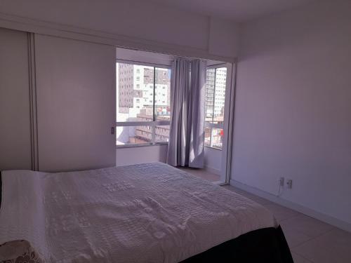 卡庞达卡诺阿Confortável apartamento na praia的一间卧室设有一张床和一个大窗户