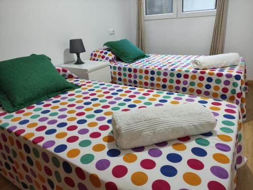 塞代拉Piso en Cedeira的一间卧室配有两张床和波卡圆点床单