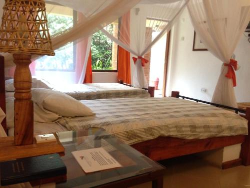 阿鲁沙前哨酒店的一间卧室配有两张床和一张玻璃桌