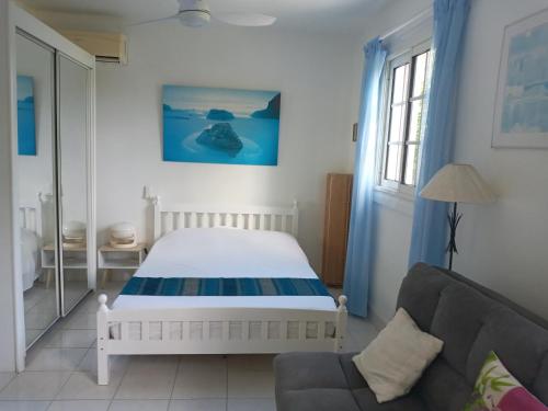 萨莱比梅Les Hauts de Terrasson的一间卧室配有一张床和一张沙发