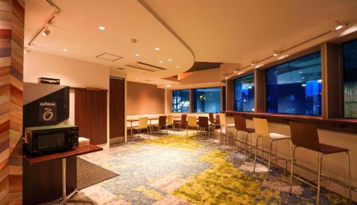 福冈新盖亚多梅玛耶酒店的一间会议室,配有椅子、电视和窗户