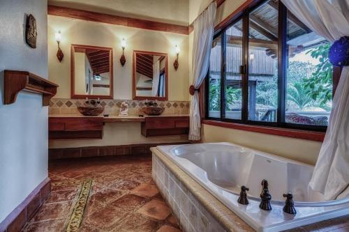 霍普金斯Almond Beach Resort at Jaguar Reef的带浴缸和窗户的大浴室