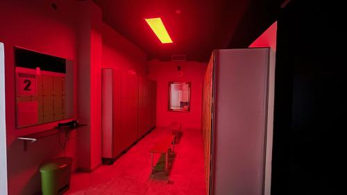 沙尔内卡Villa 3 Caparica - Lisbon Gay Beach Resort的红色的房间,走廊上设有红灯