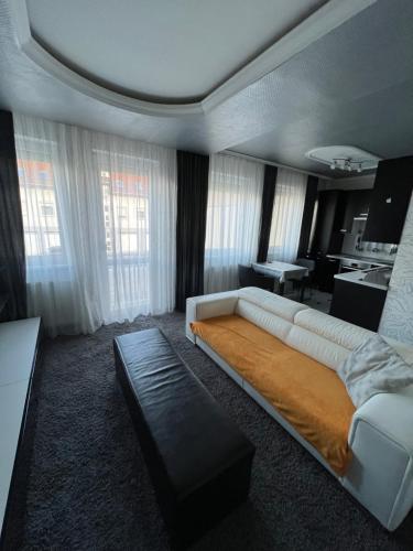 尼赖吉哈佐Prémium Apartman Nyíregyháza的卧室配有一张白色大床和一张书桌