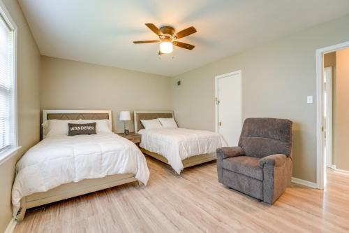 孟菲斯Memphis Vacation Rental - Walk to Graceland!的一间卧室配有两张床、一把椅子和吊扇