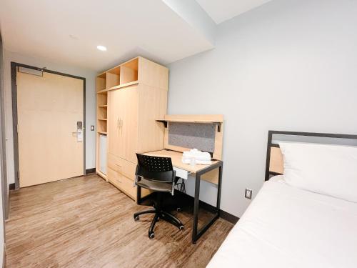 金斯顿Queen's University Residence的小房间设有一张桌子和一张床