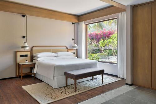 班加罗尔Mulberry Shades Bengaluru Nandi Hills - a Tribute Portfolio Resort的一间卧室设有一张床和一个大窗户