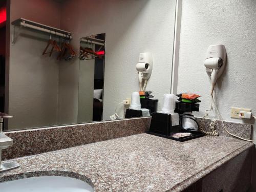 休斯顿Express Inn Hobby Airport的浴室的柜台设有水槽和镜子