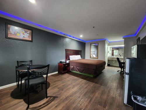 休斯顿Express Inn Hobby Airport的一间卧室配有一张床铺、一张桌子和一台冰箱