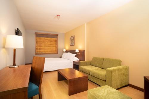 波哥大Hotel Habitel Select的配有一张床和一把椅子的酒店客房