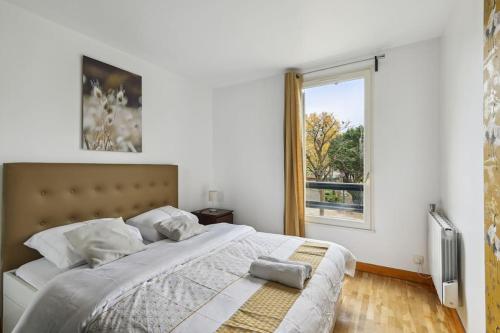 阿涅勒"Joie de vivre" - Parisian Spacious & Charming flat的一间卧室设有一张大床和一个窗户。