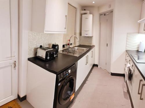 伦敦Maple House - Inviting 1-Bed Apartment in London的厨房配有洗衣机和烘干机