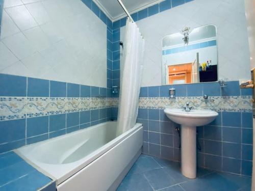 沙姆沙伊赫Luxury & stylish Naama bay flat at the centre of Sharm的蓝色瓷砖浴室设有水槽和浴缸