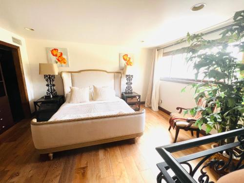 洛杉矶The Cozy Villa的一间卧室配有一张床和盆栽植物