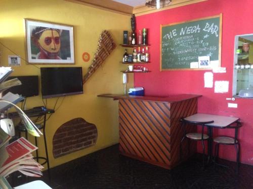 萨尔瓦多Nega Maluca Guesthouse的餐厅设有酒吧,配有两张凳子和一张黑板