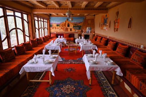 廷吉尔kasbah amlal的一间设有白色桌椅和窗户的用餐室