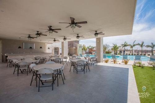 拉巴斯Hispania - Dreamy Family Homes plus Communal Pool and Playground的一个带桌椅的庭院和一个游泳池