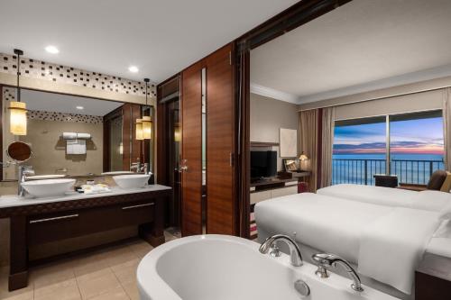 塔穆宁RIHGA Royal Laguna Guam Resort的浴室设有1张床、2个水槽和1个浴缸。