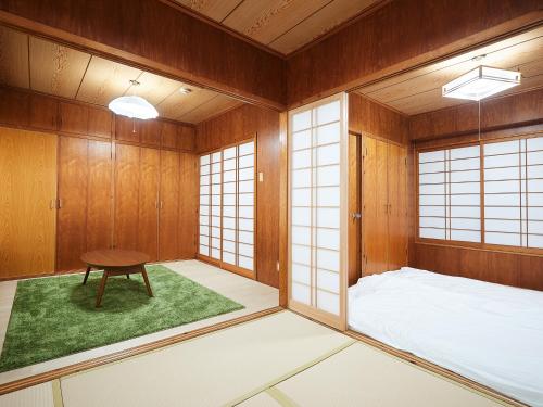 那霸Guest house II Rokumarukan的一间设有床铺和桌子的房间